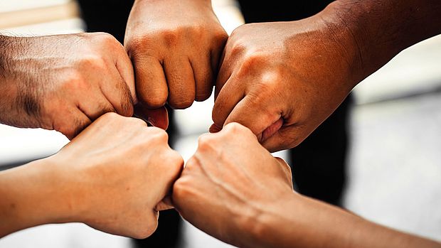 Multiple hands fist bumping