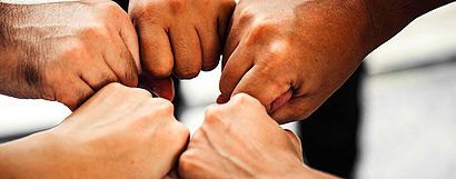 Multiple hands fist bumping