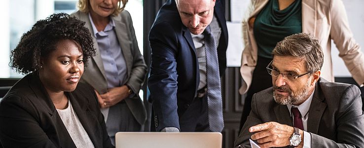 Mixed group of business people in front of a laptop