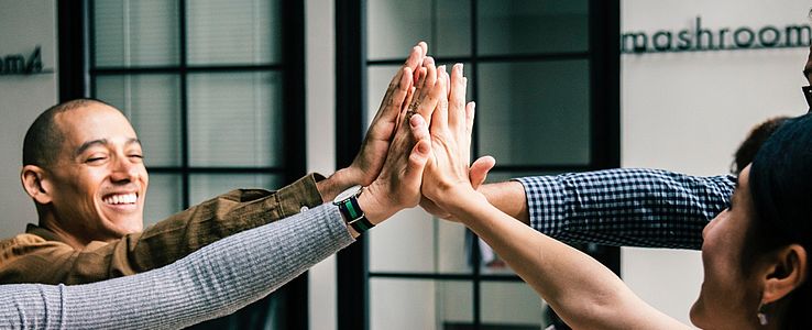 Group of mixed people collectively high-fiving